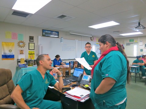 Teacher Simon Moore speaks with a student at Coachella Valley High School's Health Careers Academy.